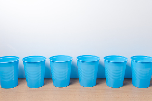 Row of light blue disposable cups