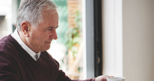 istock Coffee, retirement and mockup with a senior man drinking a beverage in his home alone during the day. Tea, thinking and morning with an elderly male pensioner enjoying a drink in his house 1441657859