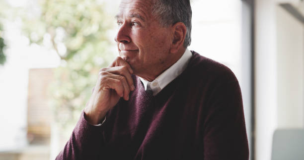 istock Thinking, retirement and nostalgia with a senior man at home, contemplating an idea while feeling positive. Smile, happy and lifestyle with an elderly male pensioner looking thoughtful in his house 1441658575