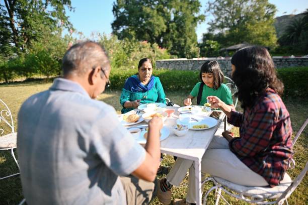 istock Multi-generation family sitting together and having breakfast on an open lawn 1441659437
