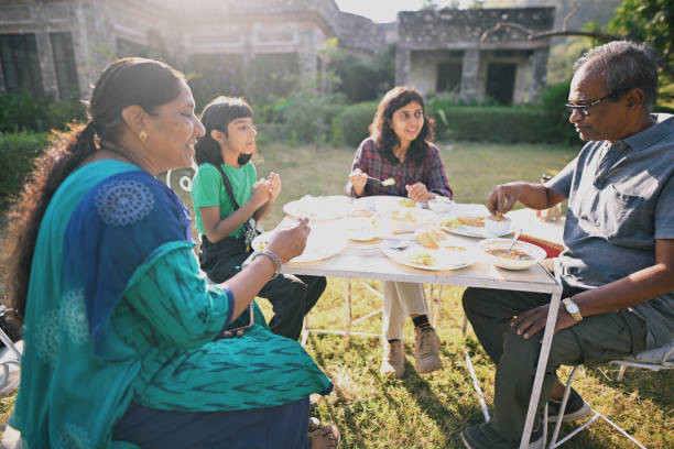 istock Multi-generation family sitting together, having breakfast on an open lawn 1441659501