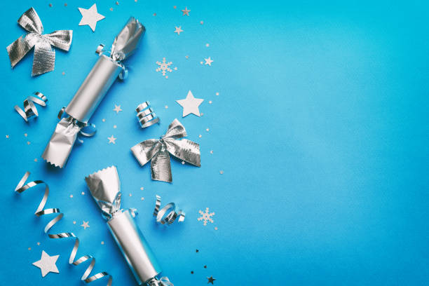 istock Christmas crackers with shiny confetti on color background, top view, copy space 1441660341