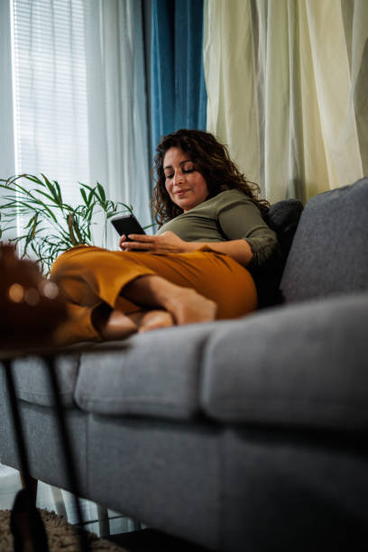 istock Woman resting on the sofa and using smart phone to pass time after coming home from work 1441660830