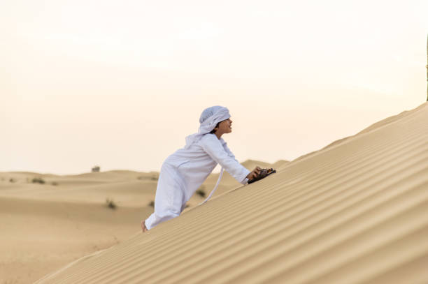 istock Arabian boy playing in the desert 1441661240