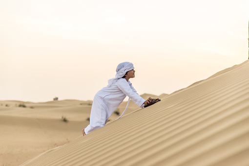 Happy kid playing in the desert of Dubai