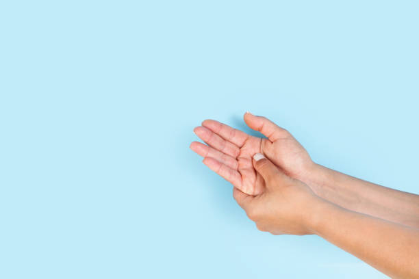 istock Woman doing a palm hand self masage on a light blue background 1441661264