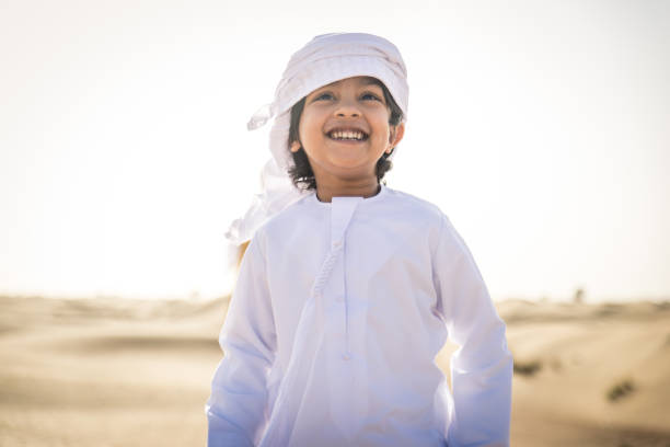 Arabian boy playing in the desert stock photo