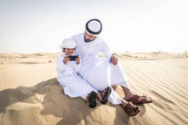 istock Arabian man and son playing in the desert 1441661399