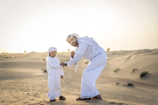istock Arabian man and son playing in the desert 1441663161