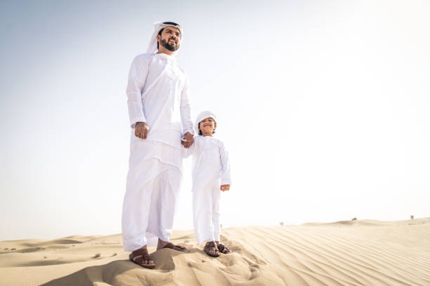 istock Arabian man and son playing in the desert 1441664769