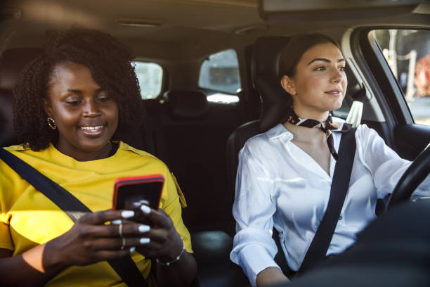 istock Young woman driving while her frined is looking up direction on a map via smart phonepassenger seat 1441665033