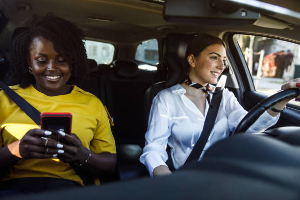 istock Young woman driving while her frined is looking up direction on a map via smart phonepassenger seat 1441665062