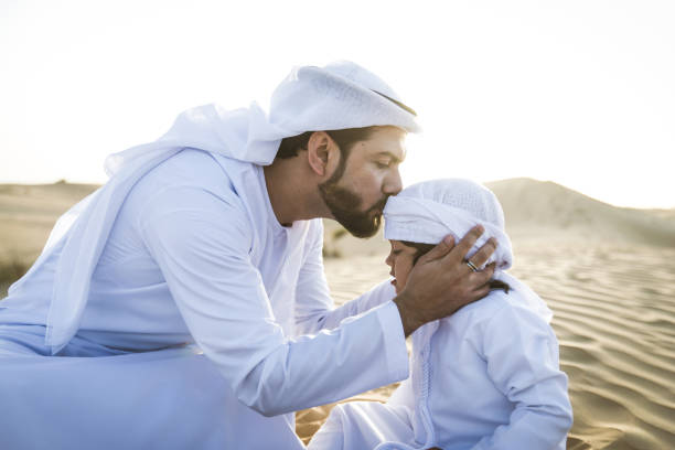 istock Arabian man and son playing in the desert 1441665372