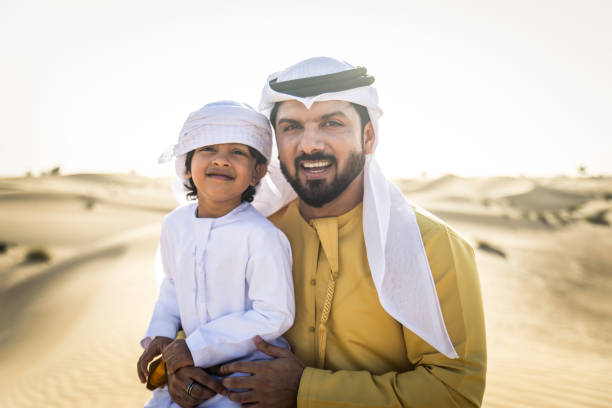istock Arabian man and son playing in the desert 1441667829