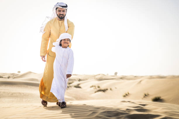 istock Arabian man and son playing in the desert 1441668986