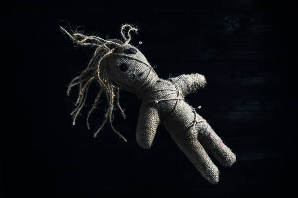 istock Female voodoo doll with pins on dark background 1441669185