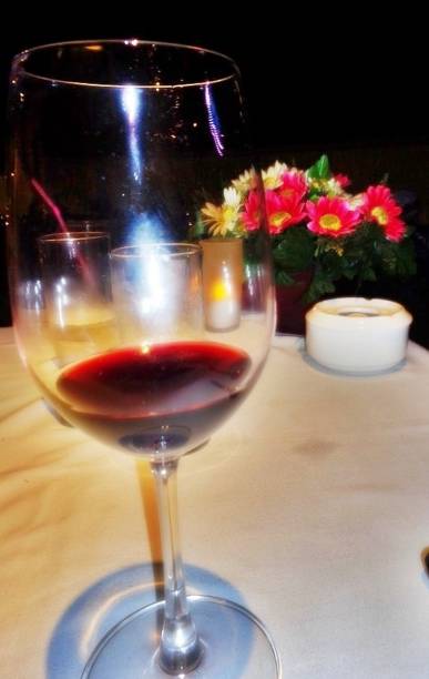 istock Glass of red wine on the table 1441669674