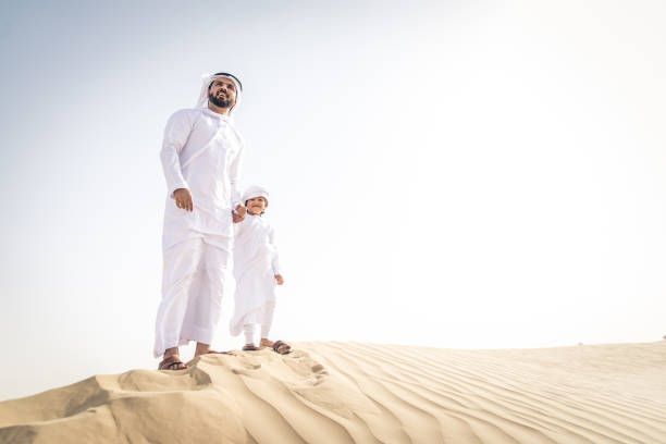 istock Arabian man and son playing in the desert 1441670451
