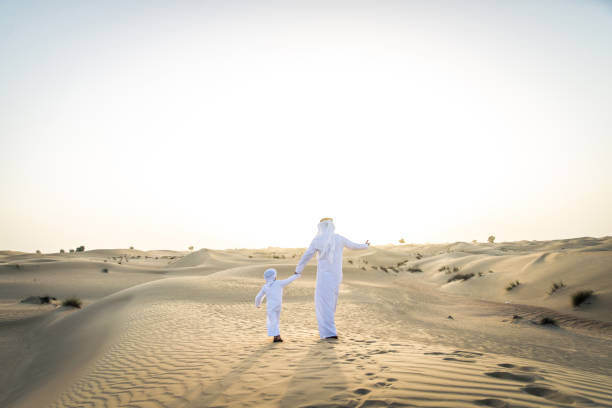 istock Arabian man and son playing in the desert 1441670645