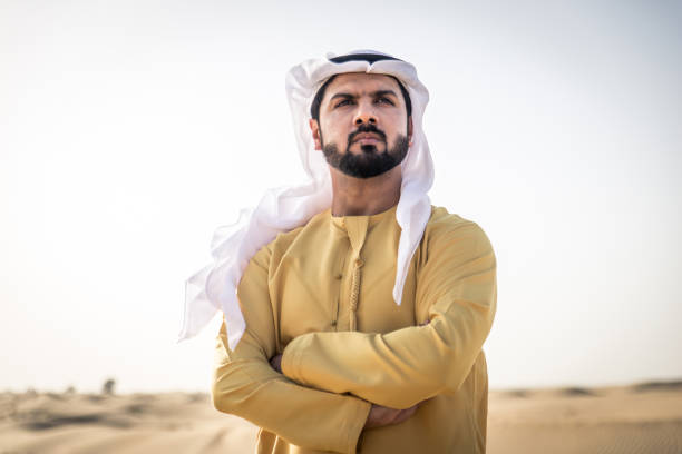 Handsome arabian man with traditional dress in the desert of Dubai