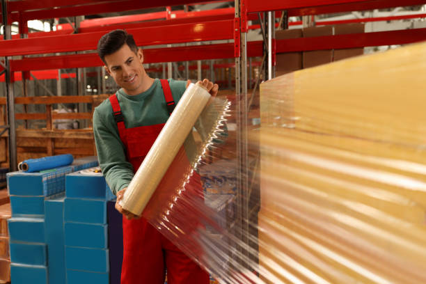 istock Worker wrapping boxes in stretch film at warehouse 1441672016