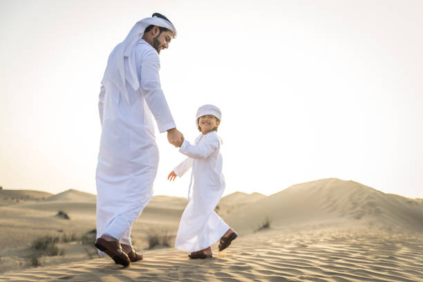 Arabian man and son playing in the desert