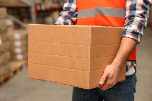 istock Worker with cardboard box in warehouse, closeup. Wholesaling 1441672190
