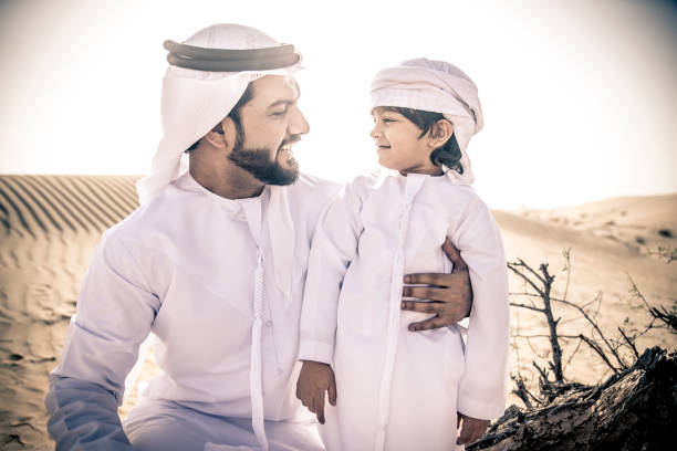 istock Arabian man and son playing in the desert 1441672202