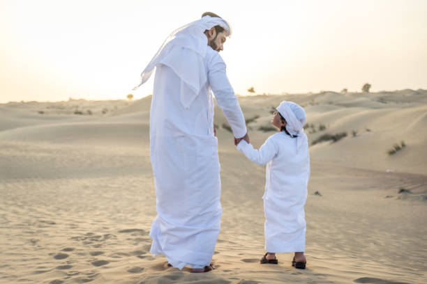 istock Arabian man and son playing in the desert 1441674461