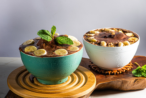 Brazilian frozen acai berry ice cream bowl. with fruits on wooden background.