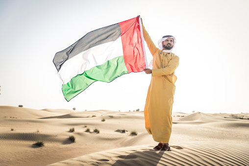Handsome arabian man with traditional dress in the desert of Dubai