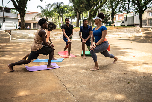Teacher and her students stretching on a square