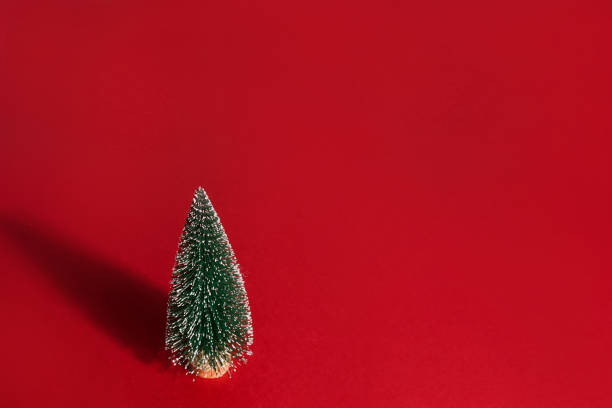 istock Christmas tree with shadow on red background, christmas card template, copy space 1441675074
