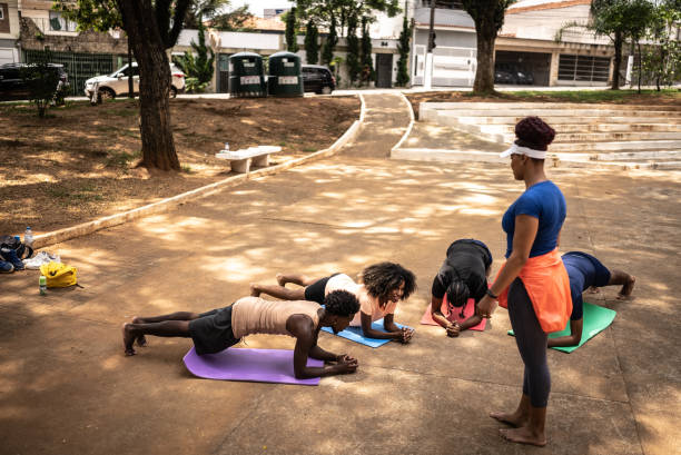 Fitness instructor teaching plank position to her students on a square