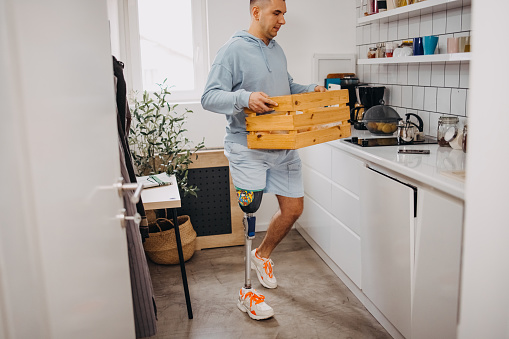 Man with one amputated leg in the kitchen