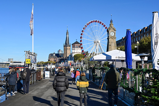 Düsseldorf, November 13, 2022 - The Rhine promenade in Düsseldorf with Ferris wheels, castle tower and St. Lambertus Basilica.