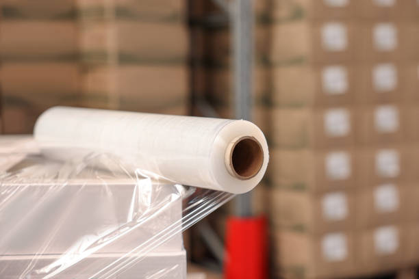 istock Roll of stretch wrap on box in warehouse, space for text 1441677016