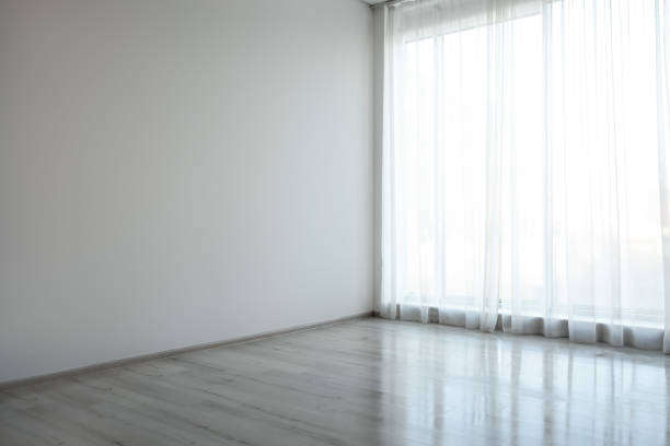 istock Empty room with white wall, large window and wooden floor 1441681413