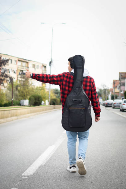 istock Guitarist waiting for the bus on bus stop 1441684252