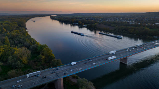 istock Highway bridge over river and ships at dusk 1441684964