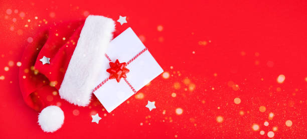 istock gift box in a hat santa claus on a red background top view with place for text 1441686977
