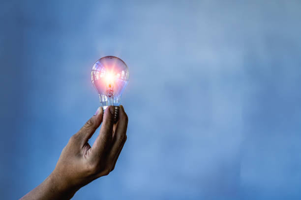 istock Innovate through ideas and inspiration. Human hand holding a light bulb to illuminate creativity and inspiration of sustainable business development ideas. 1441687429