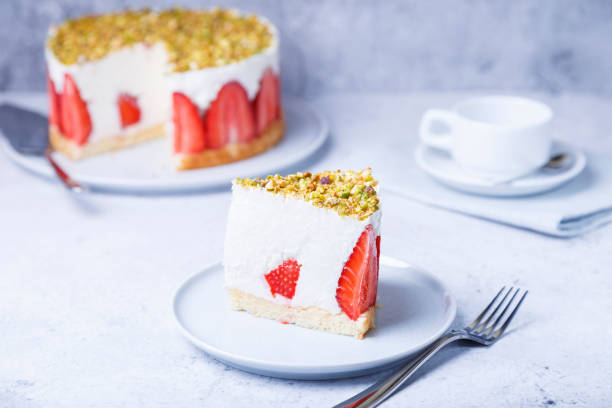 新鮮なイチゴとピスタチオのフレイジャーケーキ。フランスのクラシックデザート。白い皿の上のケーキの一部、クローズアップ、選択的な焦点 - strawberry cheesecake ストックフォトと画像