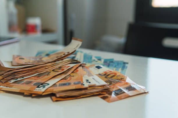 istock Handful of 20 and 50 euro bills on an empty table. 1441689290