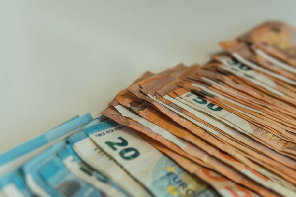 istock Row of 20 and 50 euro bills on an empty table aligned vertically. 1441689300