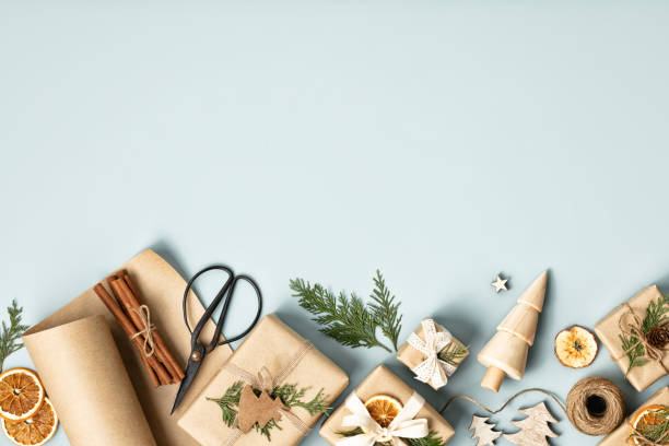 istock Natural color Christmas gift boxes on blue background, eco friendly trendy zero waste packaging flat lay top view 1441689747