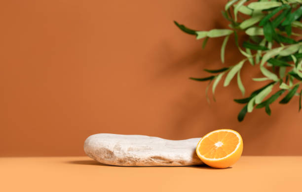Beautiful template composition of empty mockup stage for product presentation made with stone, orange fruit and olive tree leaves. stock photo