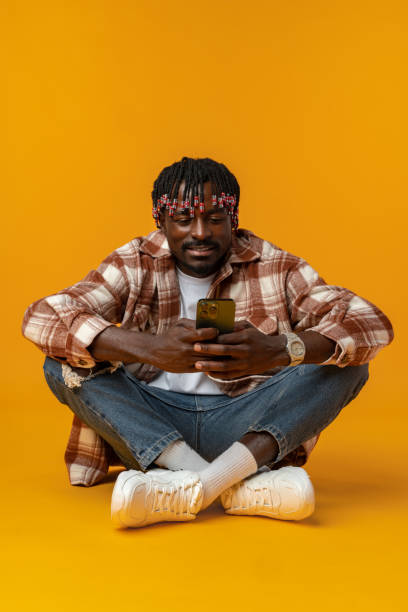 istock Young african man using smartphone over isolated yellow background 1441691044