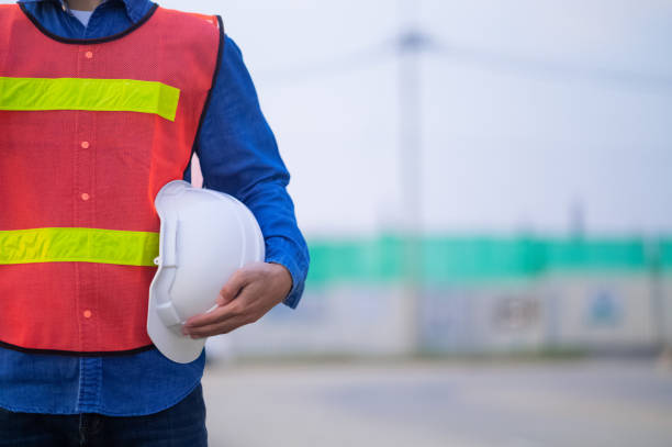 istock Close up hand holding white helmet hard hat Engineering concept, Technician holding hard hat safety hard hat sunlight background 1441691271