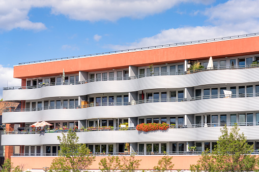 Large balconies with a wave pattern design giving character to a modern riverside apartment building in Berlin, Germany.